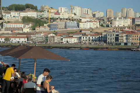 A group of people sitting at a table next to a body of water