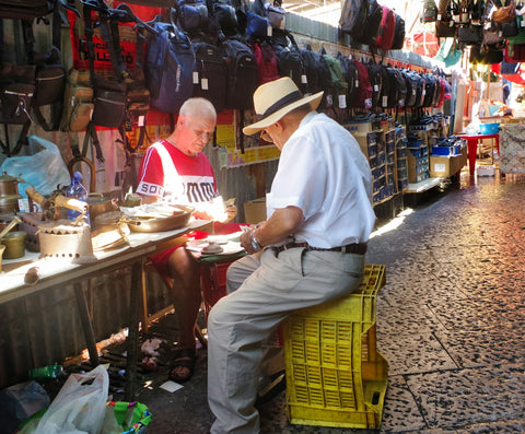 A man sitting on a bench in front of a store